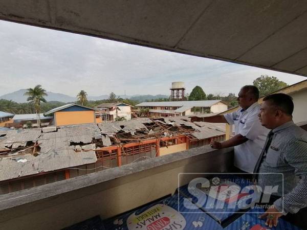 Shafruddin melihat bumbung bangunan tiga tingkat SMK Landas yang rosak teruk akibat ribut.