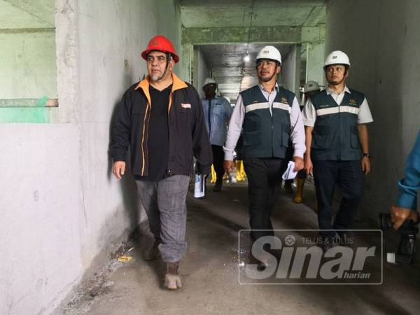 Izani (tengah) membuat pemeriksaan pada sebuah tapak projek pembinaan di Seremban 2.