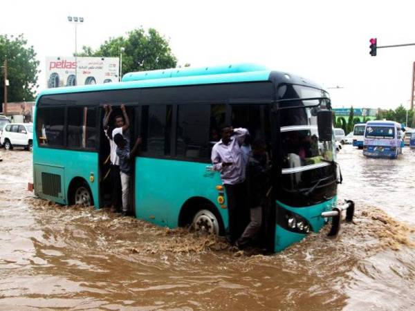 Sebuah bas melepasi sebatang jalan yang digenangi air di Khartoum.