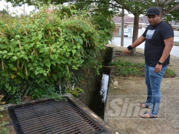 Salah seorang penduduk menunjukkan keadaan longkang sempit yang diakatan menjadi punca banjir kilat kerap berlaku.