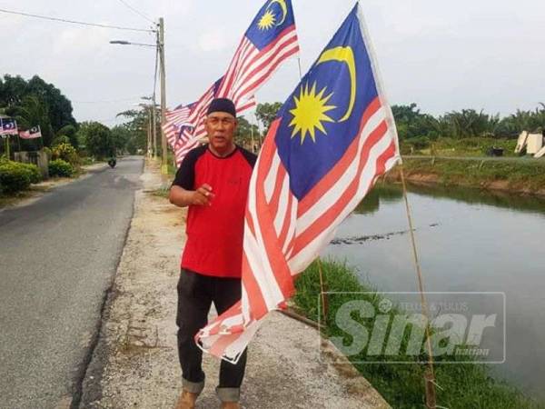Hanafiah bersama sebahagian Jalur Gemilang yang dipasang di tali air Gong Baru.