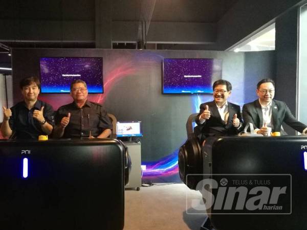 Jimmy (kanan), Exco Perumahan, Komunikasi dan Multimedia, Dzulkefly Ahmad (dua dari kiri) dan Park (kiri) mencuba sendiri salah satu permainan yang terdapat di VRinity.