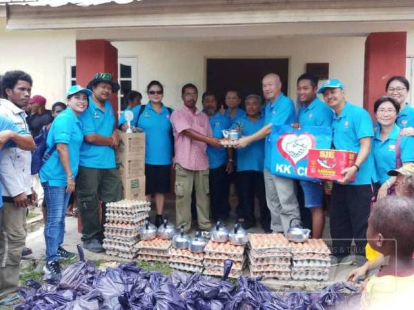 Tiong Lam menyerahkan sumbangan kepada penghulu orang asli, Mamat Pokok.