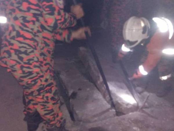 Pasukan bomba menggunakan peralatan hidraulik dan gergaji bagi merenggangkan penutup batu berkenaan. - Foto JBPM