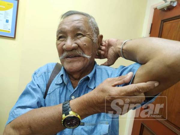 Mohd Noor menunjukkan lokasi dua peluru komunis yang masih tertanam di siku kirinya.