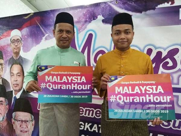 Abd Ghani (kiri) dan Amirul Aiman memegang poster Malaysia #QuranHour selepas selesai membaca al-Quran di KMPP tadi.
