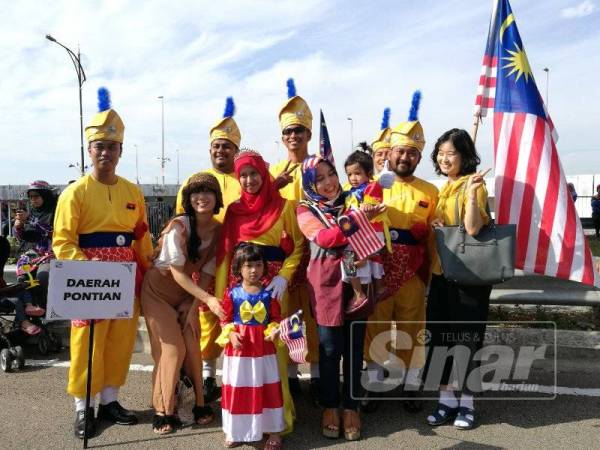 Si cilik turut merakam gambar dengan peserta perbarisan.