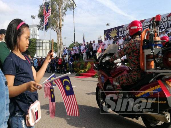 Semangat... Antara kanak-kanak yang hadir menyaksikan perbarisan sempena Hari Kemerdekaan ke-62 hari ini.