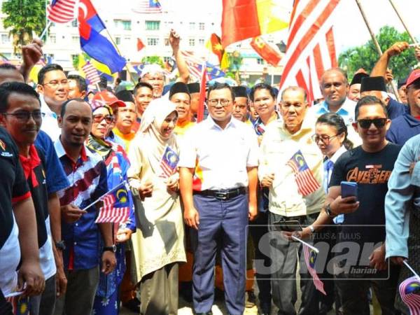 Amirudin (tengah) bersama isteri, Masdiana Muhamad hadir pada sambutan Hari Kebangsaan Peringkat DUN Sungai Tua di Padang Awam Batu Caves hari ini.
