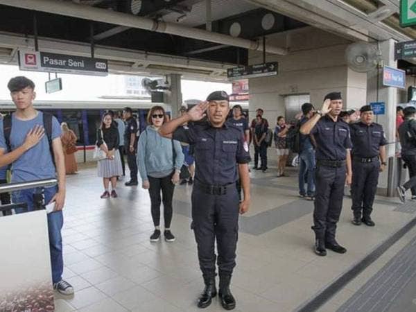 Kakitangan Prasarana bersama orang awam turut sama menyanyikan lagu Negaraku sewaktu operasi di stesen tren dihentikan seketika jam 12 tengah hari tadi. Foto: Ihsan Facebook RapidKL