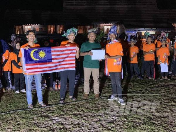 Drs. Shamsuddin menyampaikan sijil penyertaan kepada salah seorang peserta.