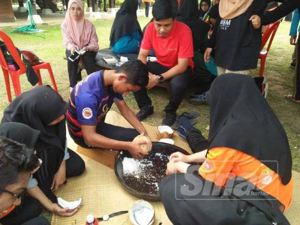 Aktiviti memasak cara kampung dengan mengukur kelapa.