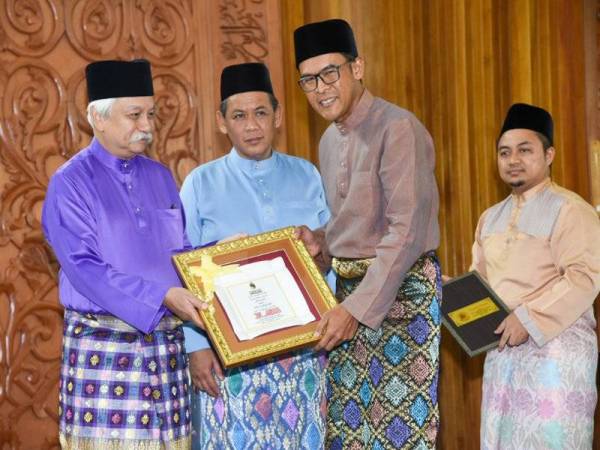 Tuanku Muhriz berkenan menyampaikan penghargaan kepada Azmir Jaafar (kanan) yang diumumkan sebagai Tokoh Anugerah Korporat.