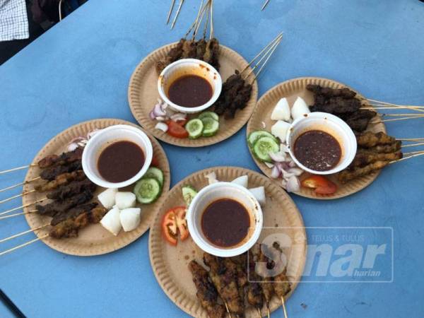 Hidangan sate limau purut bersama bawang, timun dan tomato dicicah dengan kuah kacang pedas.