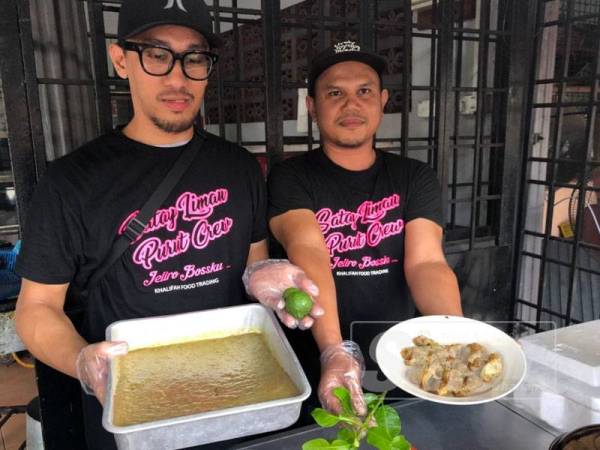 Ahmad Tamin (kiri) dan Che Azmawi nenunjukkan pes sate limau purut yang diperap sebelum dibakar.