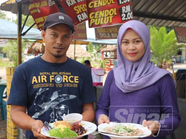 Razali dan isterinya menunjukkan laksa dan nasi ayam yang dijual pada harga RM2 sepinggan.