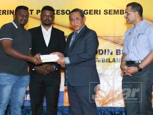 Aminuddin (dua dari kanan) menyampaikan cek kepada salah seorang pencarum. Turut kelihatan Mohammed Azman (kanan).