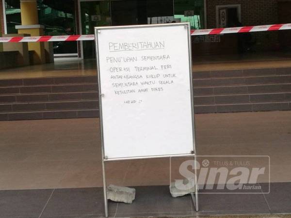 Papan tanda operasi Terminal Feri Kukup dihentikan sementara.