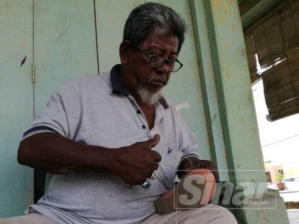 Abdul Aziz mencari rezeki berhampiran persimpangan lampu isyarat ke Ibu Pejabat Polis Daerah Kuala Krai.