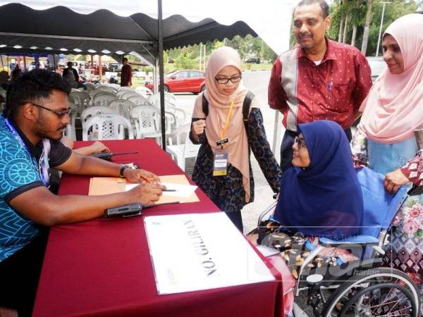 Nur Nabilah ditemani Shahina Begum (kanan) dan Shaikh Abdul Jalil (dua kanan) semasa mendaftar di UUM hari ini.