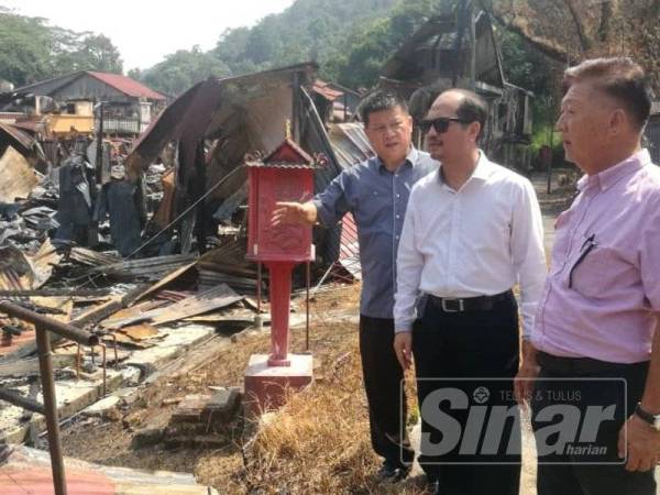 Tengku Zulpuri (tengah) meninjau kawasan kebakaran.