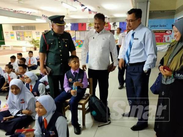 Mohd Isnin (kiri) bersama Ahli Dewan Undangan Negeri (ADUN) Permas, Datuk Seri Che Zakaria Salleh (dua dari kiri); Mohd Jefferin (dua dari kanan) dan Norlela ketika menyapa muridnya, Irfan sebelum memasuki bilik peperiksaan hari ini.