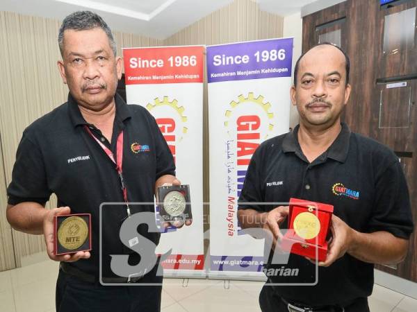 FAUZI (kanan) bersama rakannya yang juga tenaga pengajar GiatMara Pasir Puteh, Azhar Ahamad fakry menunjukkan pengiktirafan pingat emas dan perak yang diterima.