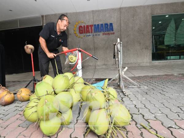 SESI demontrasi pemotongan kelapa muda menggunakan mesin coconut yang mempunyai dua fungsi dalam satu-satu masa.