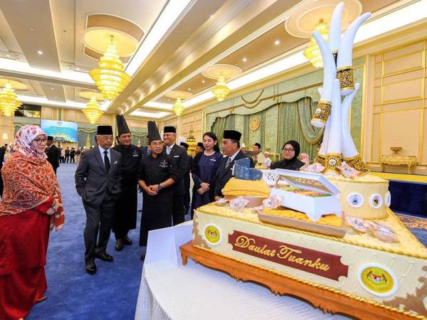 Yang di-Pertuan Agong Al-Sultan Abdullah Ri'ayatuddin Al-Mustafa Billah Shah (dua, kiri) dan Raja Permaisuri Agong Tunku Azizah Aminah Maimunah Iskandariah (kiri) berkenan melihat dan menerima persembahan kek daripada Sama-Sama Hotel pada Majlis Persembahan Kek Sempena Hari Keputeraan Rasmi Yang di-Pertuan Agong di Istana Negara hari ini. - Foto BERNAMA