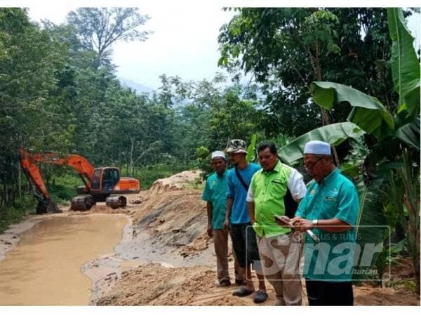 Abd Nasir (kanan) dan Mansor (dua dari kanan) meninjau kawasan terjejas banjir.