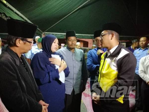Ahmad Faizal (kanan) turut hadir memberi penghormatan terakhir kepada Allahyarham.