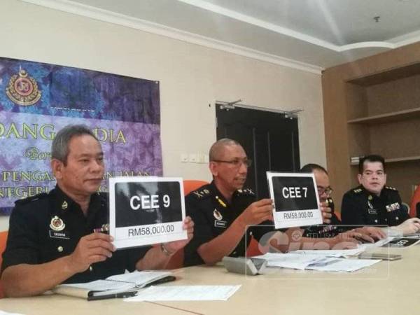 Mohamad (tengah) menunjukkan nombor pendaftaran siri CEE 7 yang meraih bidaan tertinggi iaitu RM58,000.