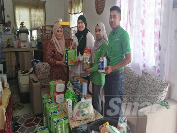 Toh (tiga dari kanan) menyampaikan sumbangan kepada Raja Rasiah di rumahnya di Batang Merbau hari ini.