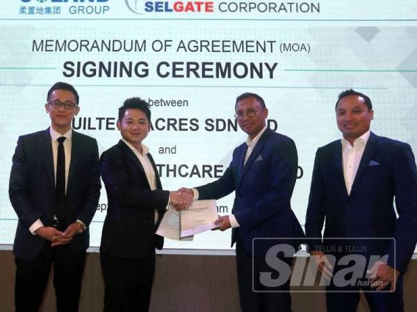 Godwin (dua dari kiri) bersalaman dengan Noor Hisham (dua dari kanan) sambil bertukar dokumen selepas menandatangani MoA di sini semalam.