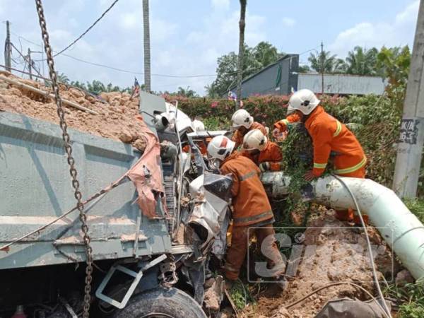 Anggota bomba bertungkus lumus untuk mengeluarkan mangsa terperangkap dalam kenderaan berat berkenaan.
