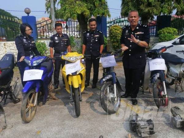 Aidi Sham (kanan) menunjukkan motosikal yang berjaya dirampas oleh Geng Intan Perdana.