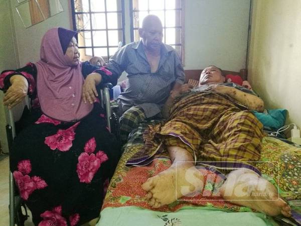 Omar (tengah) kental menjaga anaknya seorang diri selepas isterinya lumpuh sejak dua tahun lalu.