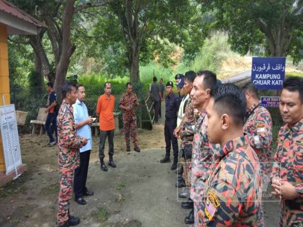 Ketua Polis Daerah Kuala Kangsar, Asisten Komisioner Razali Ibrahim (dua dari kanan) memberi taklimat kepada anggota bomba yang menjalankan tugas mencari mangsa hari ini.