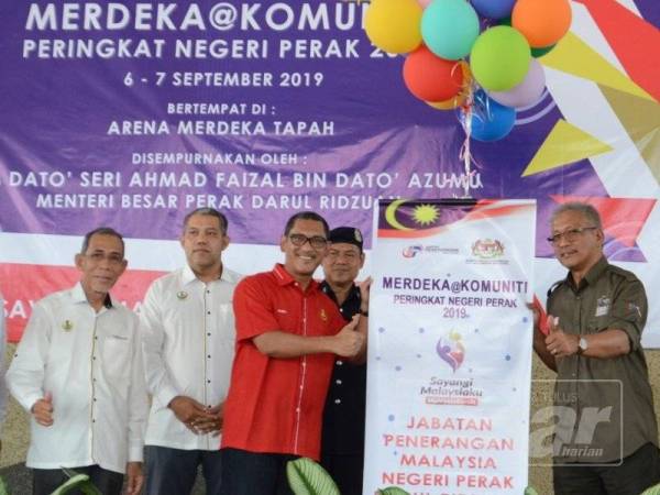 Ahmad Faizal (tiga dari kiri) menyempurnakan gimik perasmian Merdeka@Komuniti peringkat negeri Perak di Arena Merdeka Tapah hari ini.