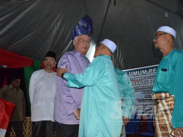Najib disambut Mahfodz sebelum berucap dalam Ceramah Umum Penyatuan Ummah di Kampung Parit Kassan, Bukit Gambir, Tangkak malam tadi.