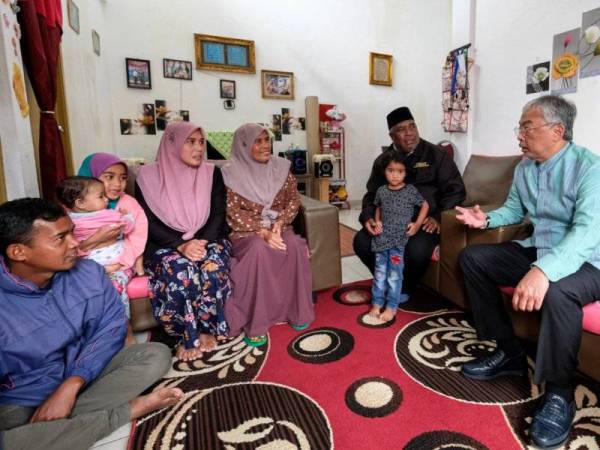 Al-Sultan Abdullah berkenan bersama keluarga Shariff Bahsoon (dua,kanan) yang merupakan masyarakat Orang Asli ketika baginda melawat perkampungan Sungai Ruil hari ini. -Foto Bernama