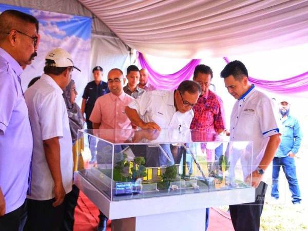 Wan Rosdy (tiga dari kanan) melihat model rumah projek tersebut.