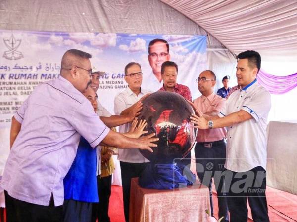 Wan Rosdy (tengah) menyempurnakan simbolik perasmian projek Rumah Makmur Tanjung Gahai bersama Ramli (kiri) hari ini.