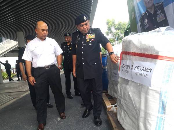 Roslan menunjukkan antara dadah yang akan diluluskan kepada Johari di Seremban.