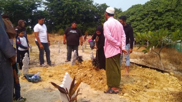 Ahli keluarga menyiram air di pusara kanak-kanak malang itu yang selamat dikebumikan di di Tanah Perkuburan Islam Serkam di sini, hari ini.