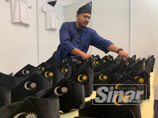 Alif menjual tanjak dengan harga RM30 pelbagai saiz di gerai jualan Himpunan Penyatuan Ummah di Pusat Dagangan Dunia Putra (PWTC), Kuala Lumpur hari ini.