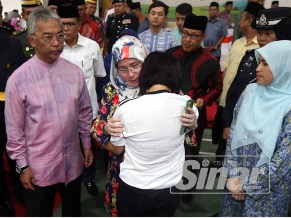 Tunku Azizah menenangkan Ho Poh Ling, 40 yang merupakan anak mangsa yang maut dalam kebakaran tersebut di Dewan SJK(C) Sungai Lembing di sini hari ini.
