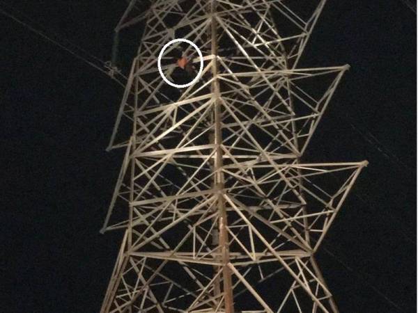 Anggota bomba terpaksa mengambil masa hampir satu jam untuk memujuk seorang lelaki yang cuba terjun dari menara elektrik di Sungai Pelek di sini malam tadi. FOTO: Ihsan Bomba Selangor