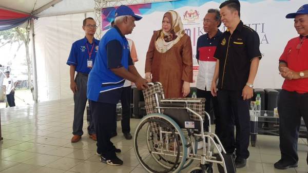 Rina menyampaikan sumbangan kerusi roda pada Program Komuniti Sejahtera di PPR Perkasa, Kuala Lumpur hari ini.