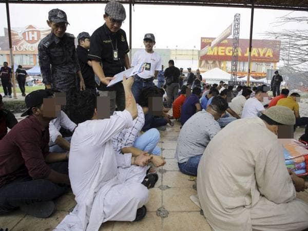 Khairul Dzaimee memeriksa dokumen warga asing yang ditahan bagi menentukan dokumen dan pasport yang dimiliki mereka sama ada tulen atau sebaliknya pada Operasi Bersepadu di sekitar Pusat Komersil Nilai 3 hari ini. - Foto Bernama